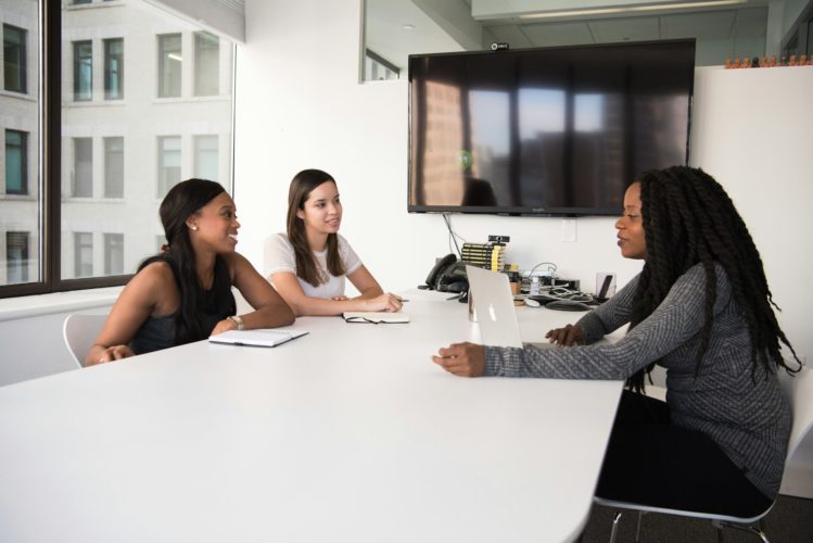 selective focus photography of people sitting on chairs while writing on notebooks