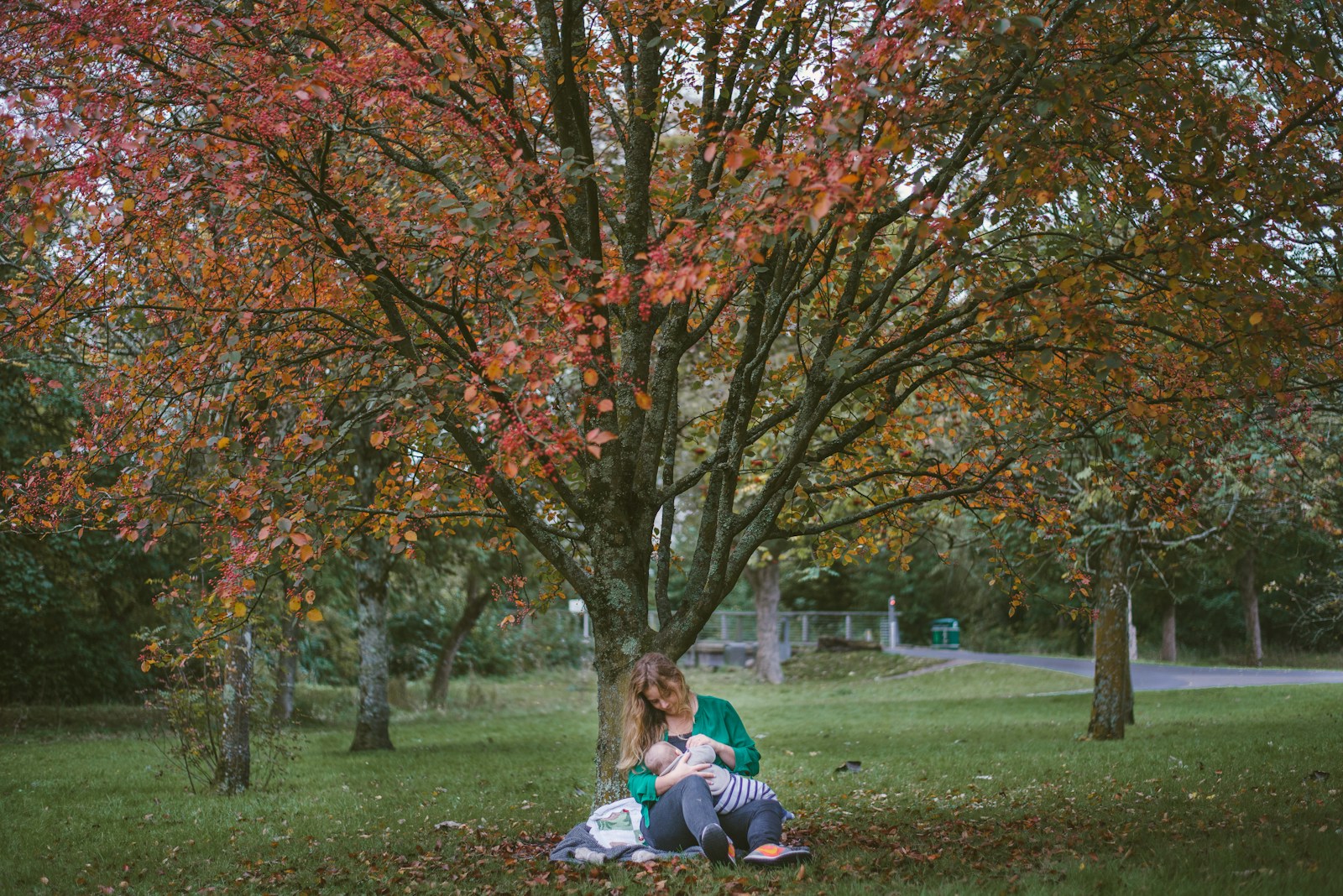 Photo by Dave Clubb woman holding baby sitting under the tree