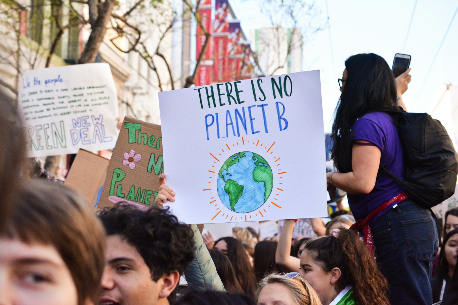 Photo by Li-An Lim person holding there is no planet b poster