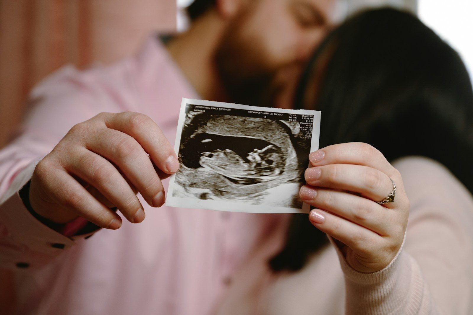 Couple holding ultrasound picture of their baby